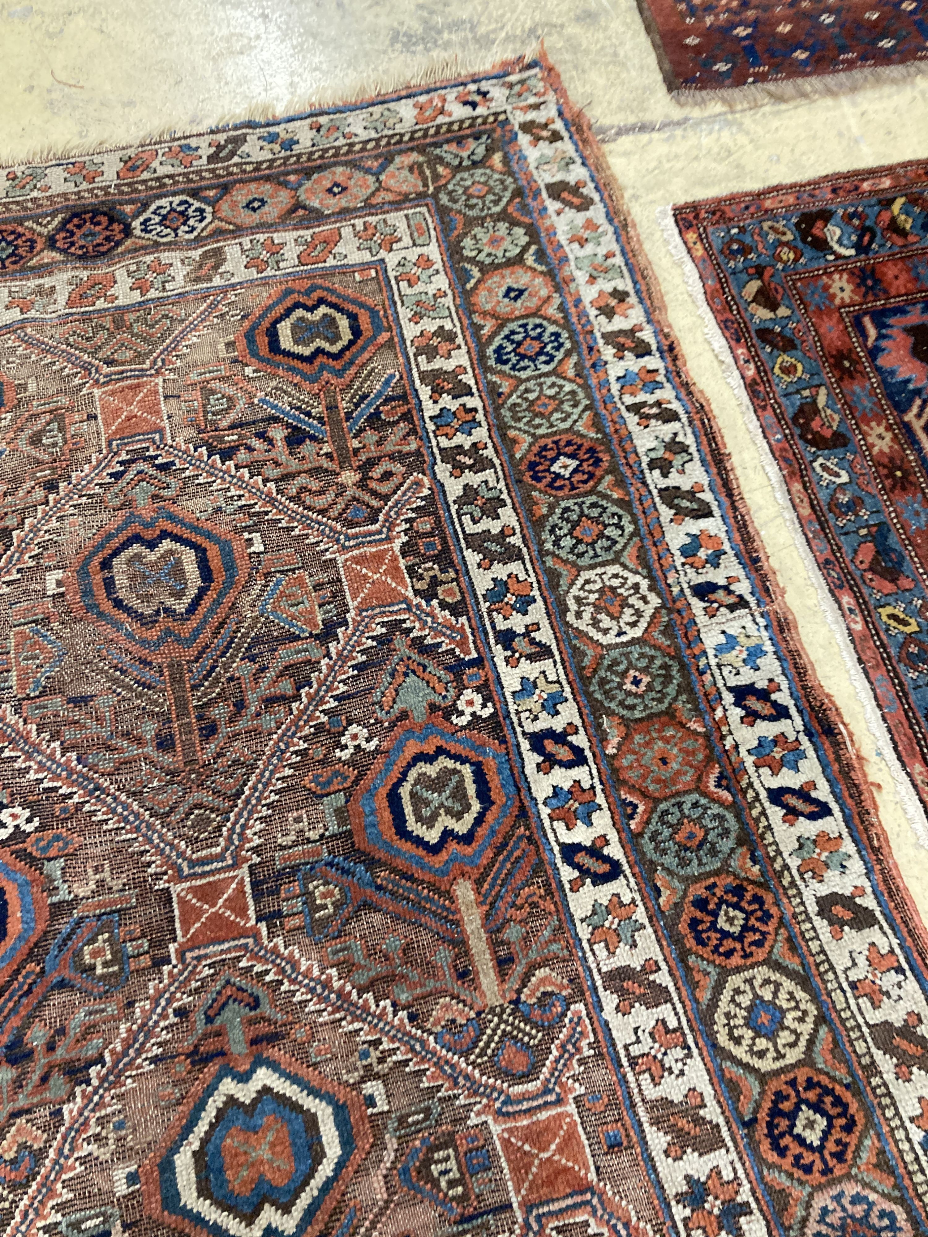 An antique Caucasian red ground rug, 250 x 125 cm and a smaller Shiraz rug.